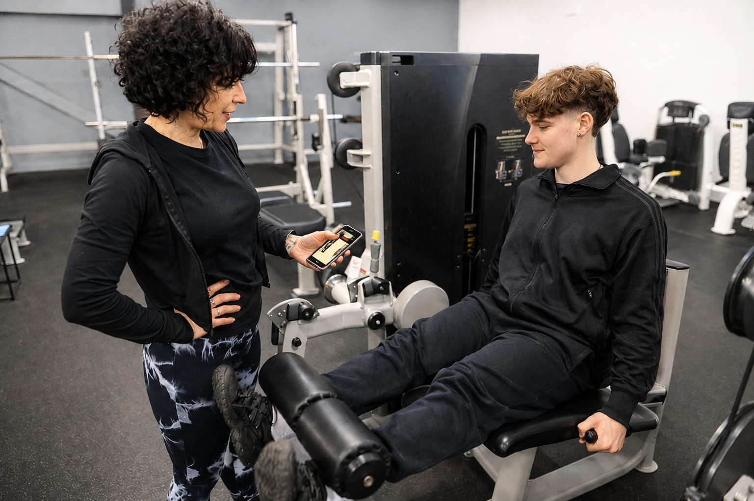 Coaching sur mesure : une coach Avenir Fitness accompagne un adhérent sur machine à Langon